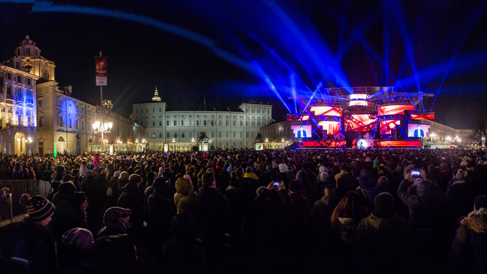 Veduta notturna di piazza Castello a Torino illuminata dallo spettacolo per i giochi mondiali universitari