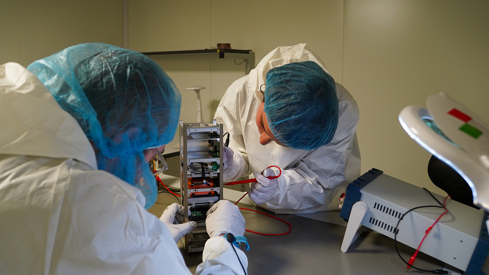Due ricercatori al lavoro per la costruzione di un piccolo satellite CubeSat