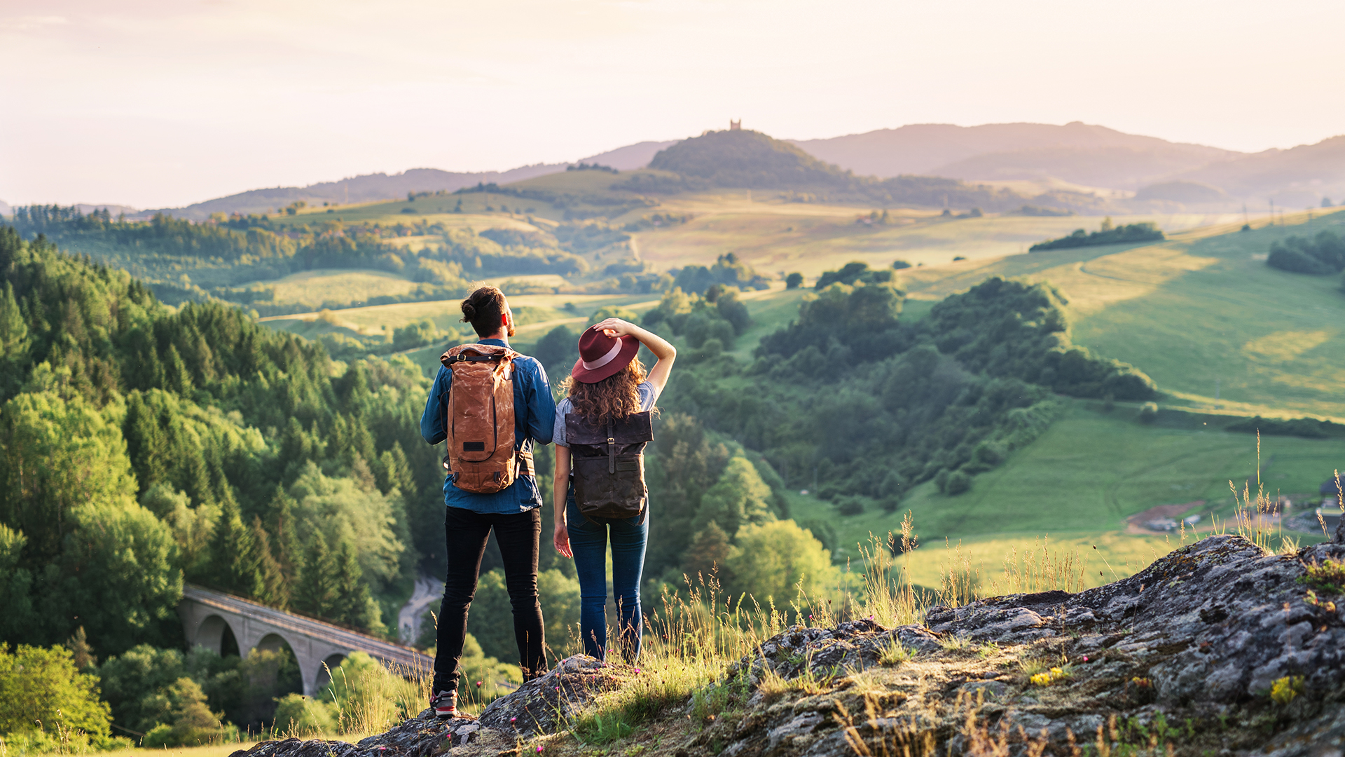 Foto di due persone che fanno una gita tra le colline con paesaggio campestre