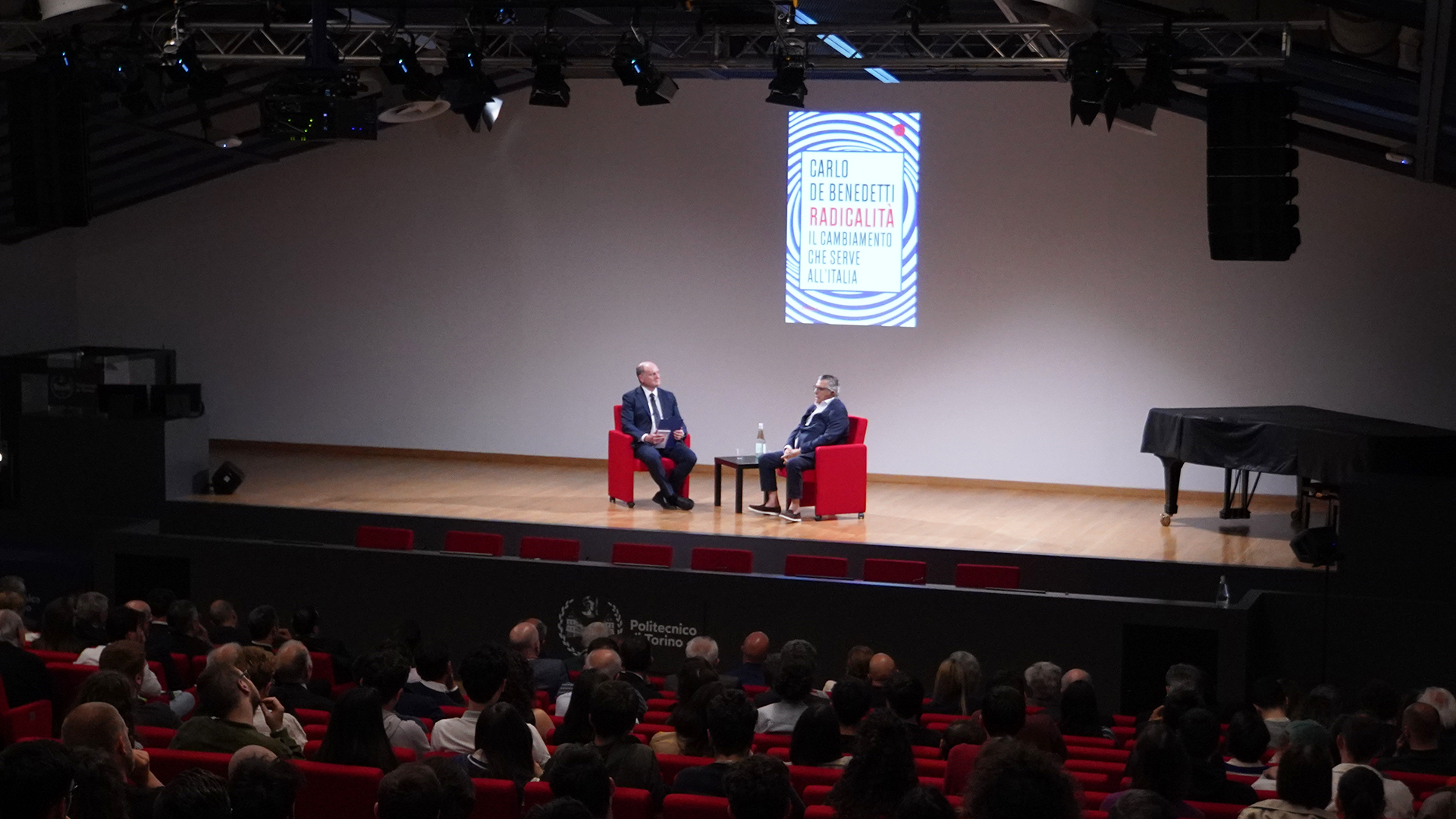 Foto del palco e del pubblico in Aula Magna con gli ospiti sul palco