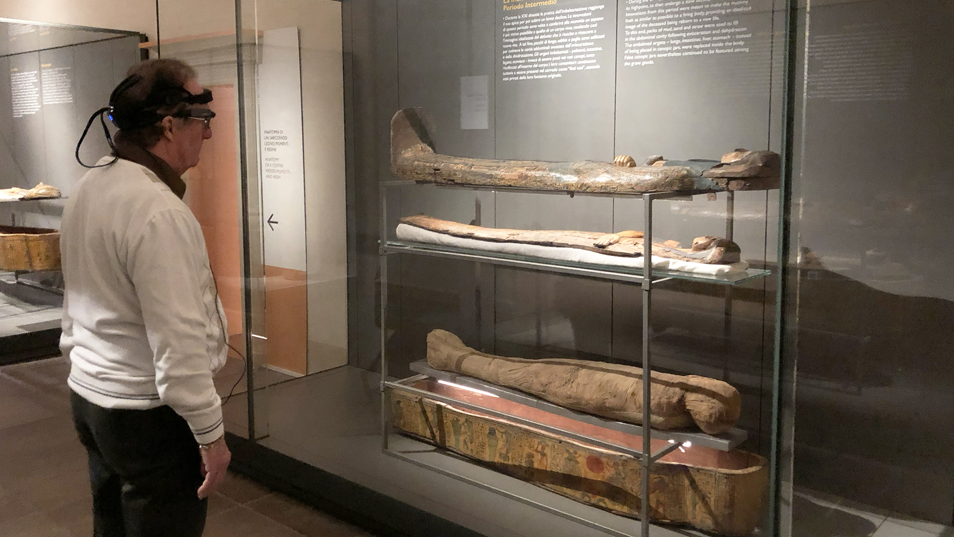 Una persona osserva una mummia al Museo Egizio
