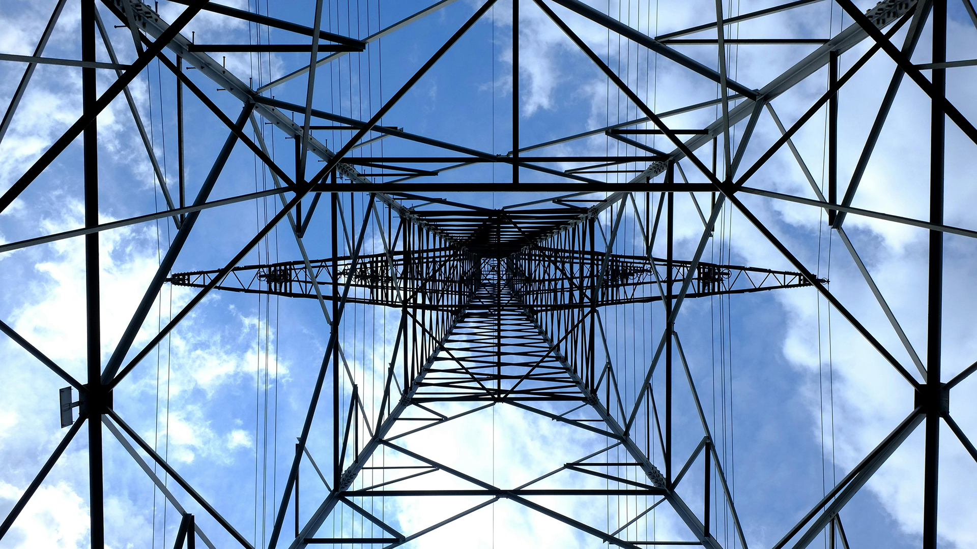 Foto di un traliccio dell'elettricità sotto il cielo blu e le nuvole