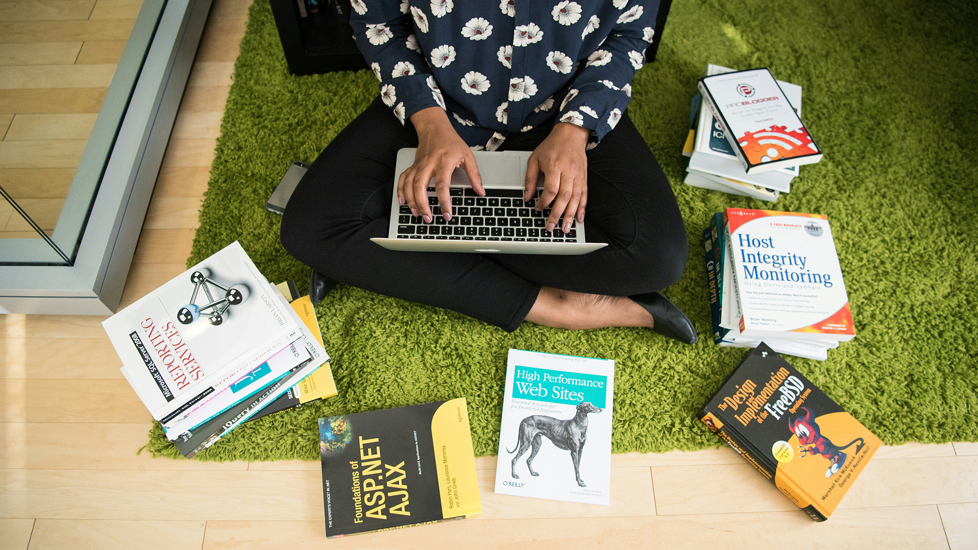 Foto di una ragazza che lavora al computer circondata da libri