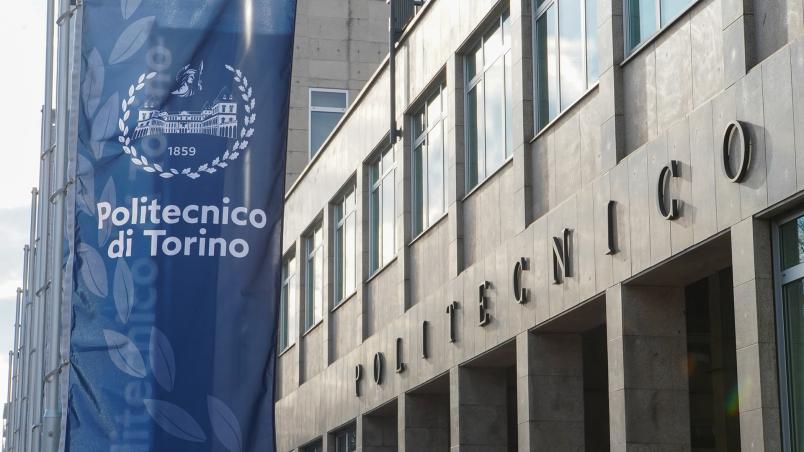 Foto della facciata del Politecnico con uno stendardo blu con logo di Ateneo