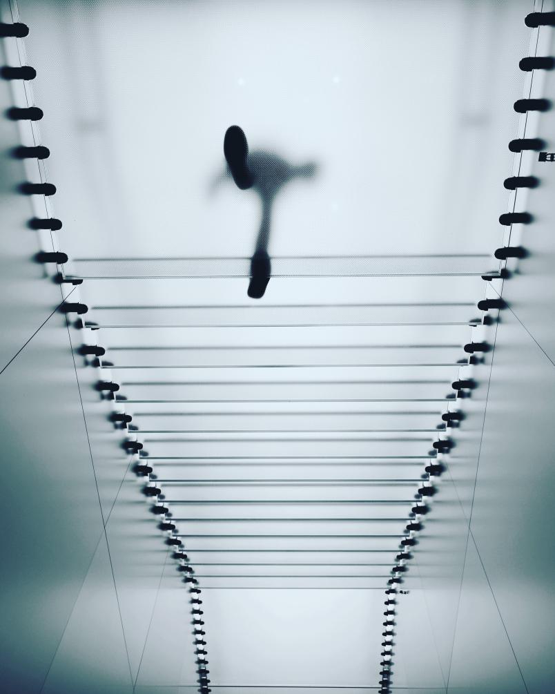 Foto di una persona che cammina su una scala di vetro