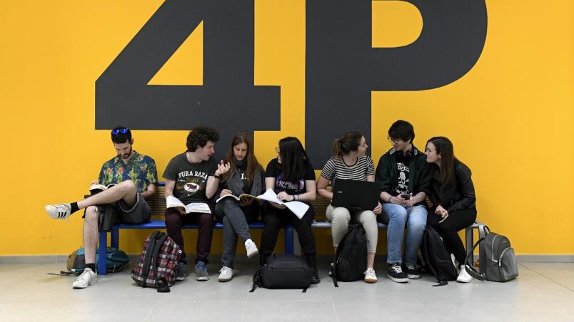 Un gruppo di ragazzi studia e chiacchiera su una panchina