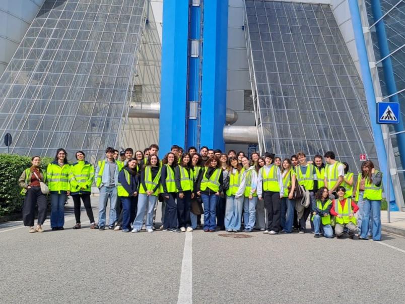 Foto di gruppo di studenti con giacchetti gialli catarifrangenti davanti al TRM di Torino