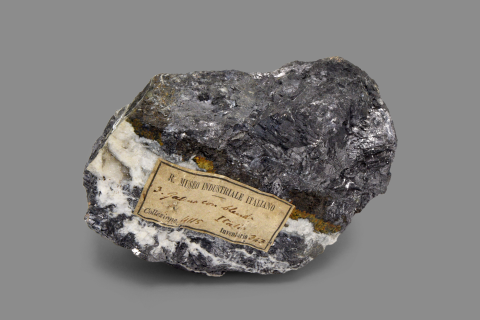 Minerale di colore grigio con striature bianche e sfumature gialle