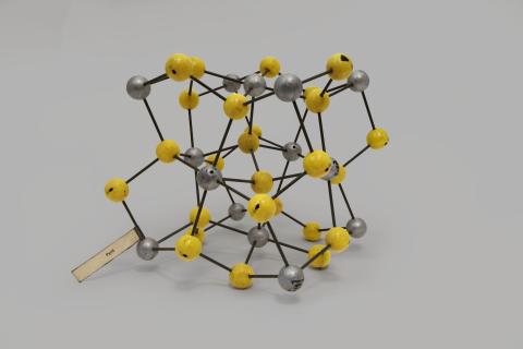 Modello di reticolo cristallino della pirite formato da sfere grigie e gialle
