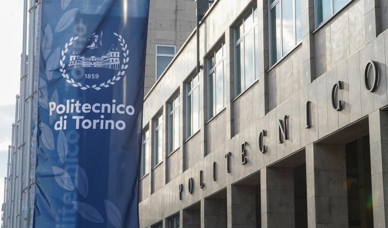La facciata del Politecnico di Torino con stendardi blu con logo