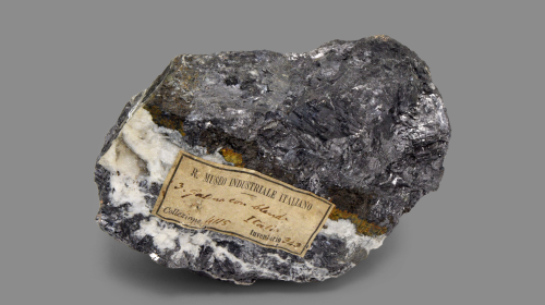 Minerale di colore grigio con striature bianche e sfumature gialle