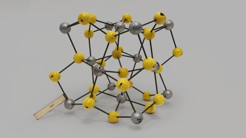 Modello di reticolo cristallino della pirite formato da sfere grigie e gialle